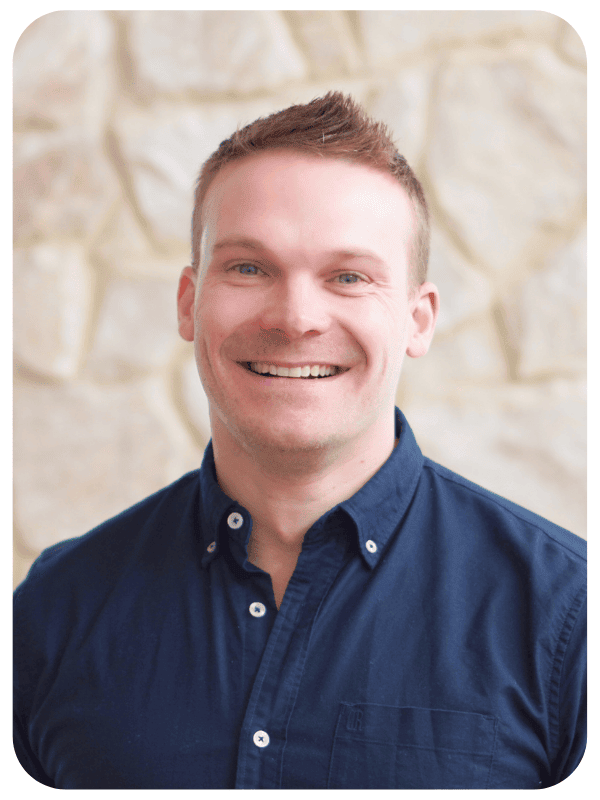 A man in a business shirt, smiling at the camera.