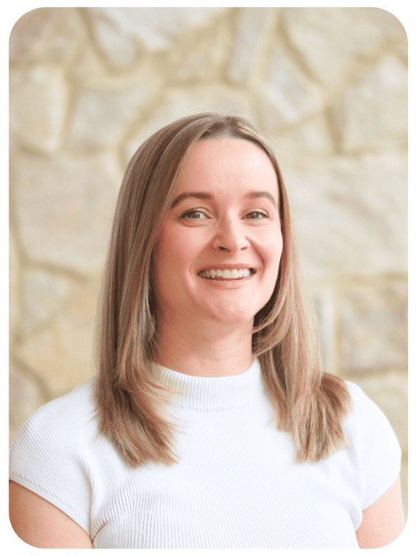 A woman in a corporate shirt, smiling at the camera.